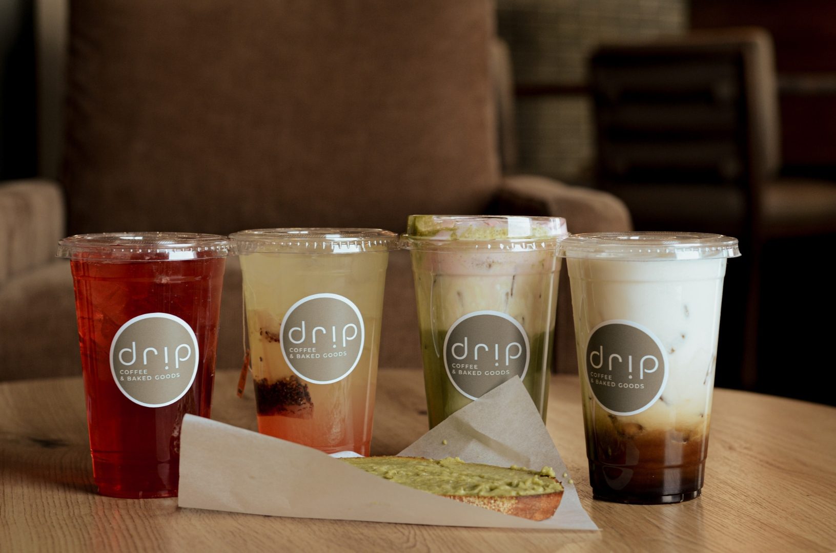 Four signature Drip Coffee drinks on a warm wood table